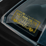 Gold text and broken heart design on a car window