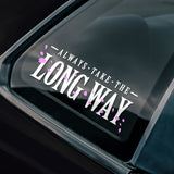 Car window with a decal reading 'Always take the long way' on a black car.