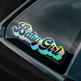 Holographic 'Baby Girl' decal on a car window.