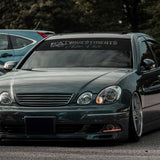 Black car with a custom decal on the windshield in an outdoor setting