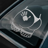 Car window with a silver decal on the window. The decal is a butt with a hand slap image on it.