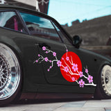 Black car with cherry blossom and red sun design on a blurred background