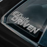Sticker with 'Daily Driven' text on a car window