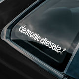Sticker with 'demonic diesels' text on a car window