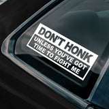Sticker on a car window with humorous text 'Don't honk unless you've got time to fight me'.