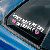 Sticker on a car window with text 'Don't make me cry I'm fragile' and broken heart symbols.