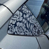 Car side mirror with floral pattern on a silver car