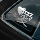Silver heart-shaped decal with Japanese letter for "love" on a black surface
