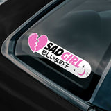 Sticker with 'SAD GIRL' text and a broken heart on a car window.