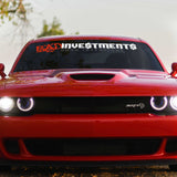 Red car with 'Bad Investments' decal on the windshield
