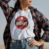 A person wearing a white t-shirt with a red and black 'BAD INVESTMENTS AUTO CLUB' logo and a skull design, paired with a plaid shirt and blue jeans.