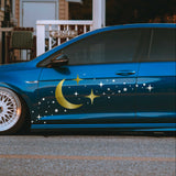 Blue car with star and moon design parked on a street