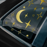 Various star and moon decals shown on the rear window of a black car.