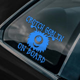 Car window with a blue 'Crotch Goblin On Board' decal on a black car.
