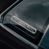 Close-up of a car window with 'Emotionless' decal 