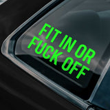 Green decal reading 'FIT IN OR FUCK OFF' on a car window