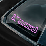 Pink 'I ❤️ manual' sticker on a car window
