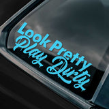 A decal saying "Look Pretty Play Dirty" shown on the rear window of a black car