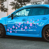 Blue car with cherry blossom decal on a street
