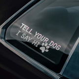 Car window with a decal that says 'Tell your dog I say hi' on a black car.