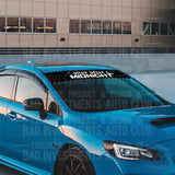 Alive After Midnight Windshield Banner Decal by Bad Investments Auto Club shown on a blue Subaru car.