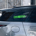 Bad Luck with a sad face sticker on car window by Bad Investments Auto