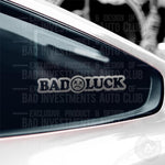 Bad Luck with a sad face sticker on car window by Bad Investments Auto