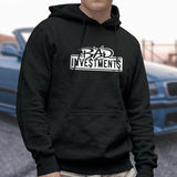 Male model wearing a black pullover hooded sweater with “Bad Investments” design on it