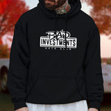 Male model wearing a black pullover hooded sweater with “Bad Investments Auto Club” design on it