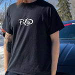 Male model wearing a black tshirt of our simple "BAD" design